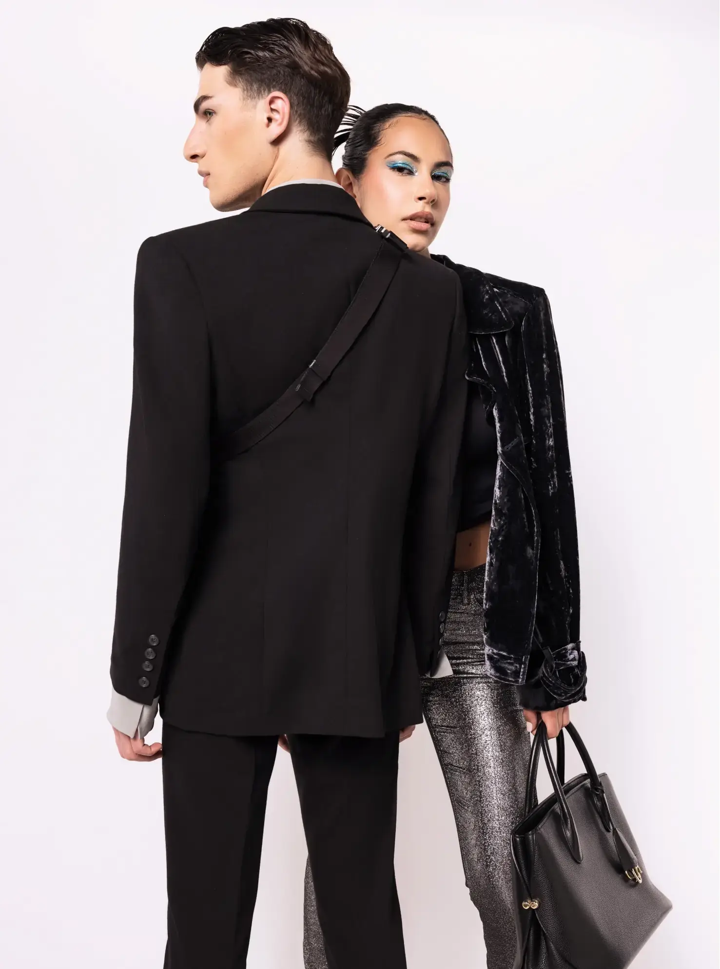 Male model turned back (left) and female model (right) posing in luxury pieces.